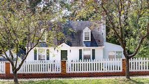 A white house with a white picket fence around it;