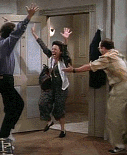 Julia Louis-Dreyfus, Jerry Seinfeld, and Jason Alexander are dancing in the doorway;