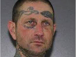 Travis Bowcock's jail photo showing his face and part of his neck tattoos;