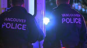 Two Vancouver police officers standing at a crime scene;